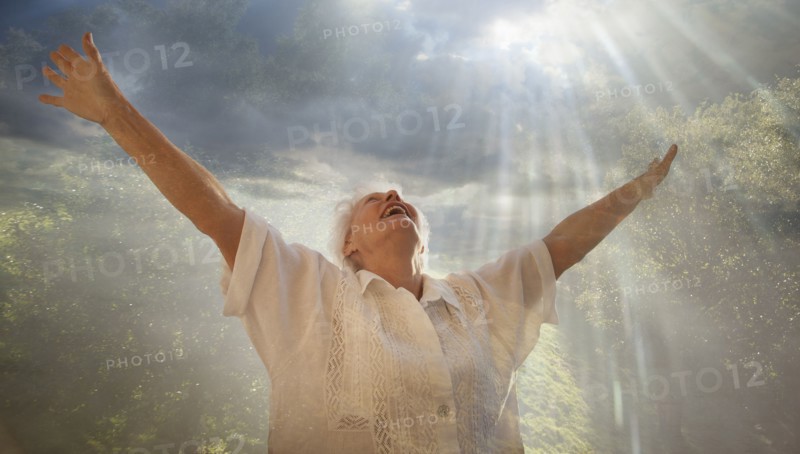 Smiling Caucasian woman looking up at sunbeams