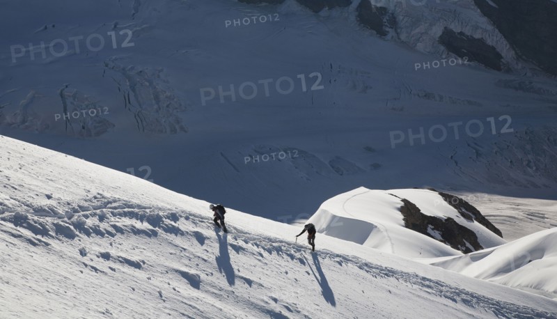 Caucasian men hiking on mountain in winter