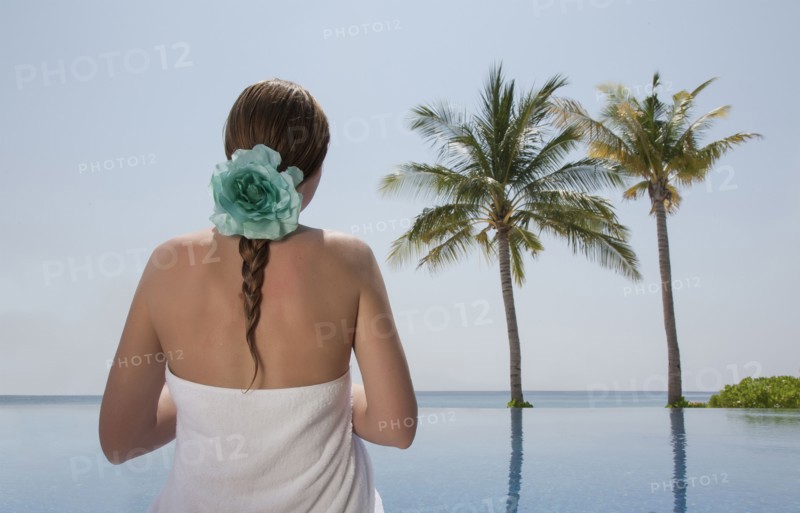 Caucasian woman admiring palm trees near ocean