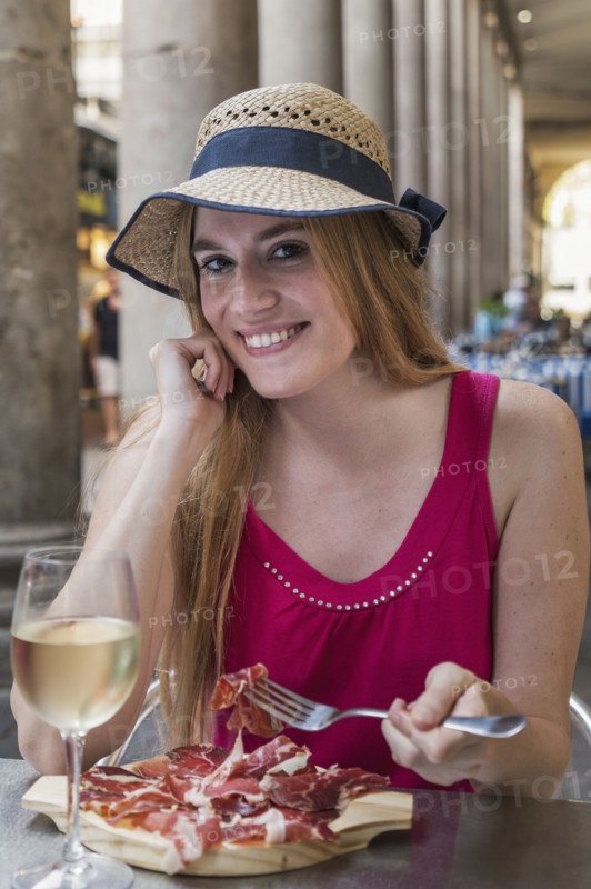 Portrait of smiling Caucasian woman eating meat at restaurant