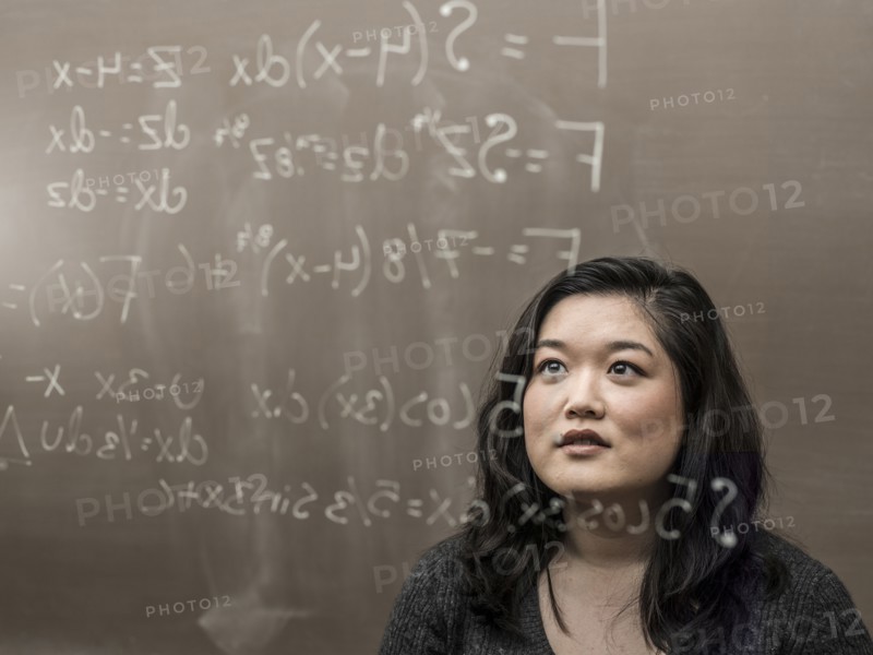 Korean student looking at formula on glass wall