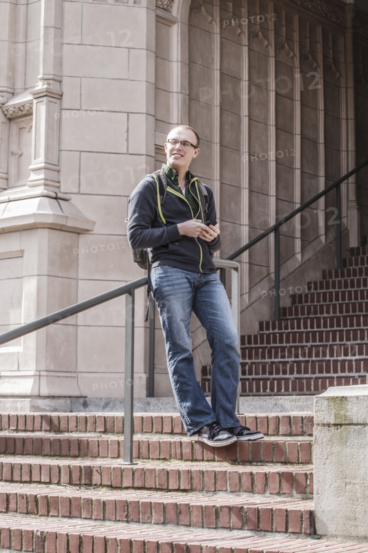 Caucasian student standing on campus staircase