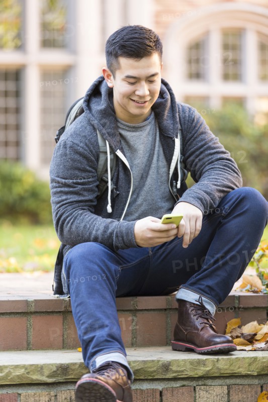 Mixed race college student sitting on campus steps
