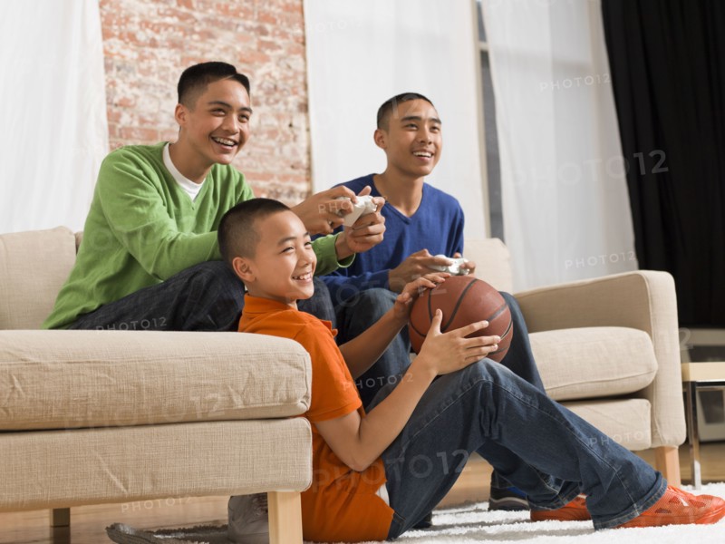 Mixed race brothers playing video games together