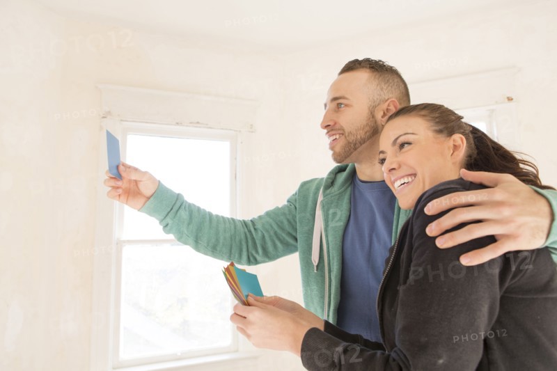 Mixed race couple selecting color swatches in new home