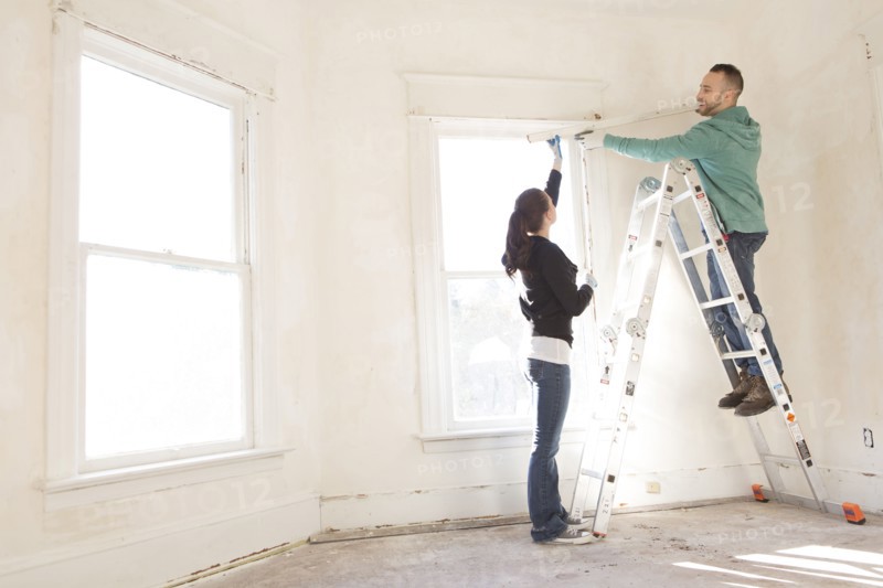 Mixed race couple installing shade in new home
