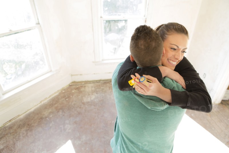 Mixed race couple hugging in new home