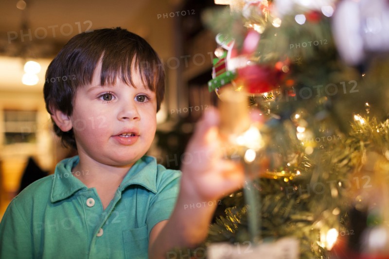 Caucasian boy decorating Christmas tree