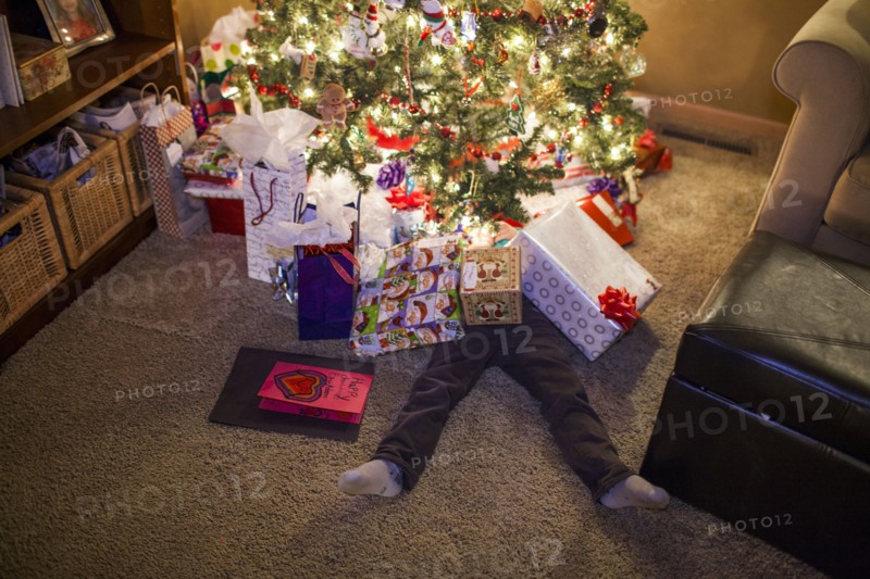Caucasian boy buried in Christmas gifts