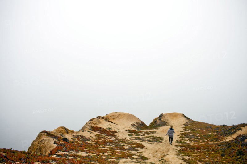 Caucasian woman walking on sand dunes