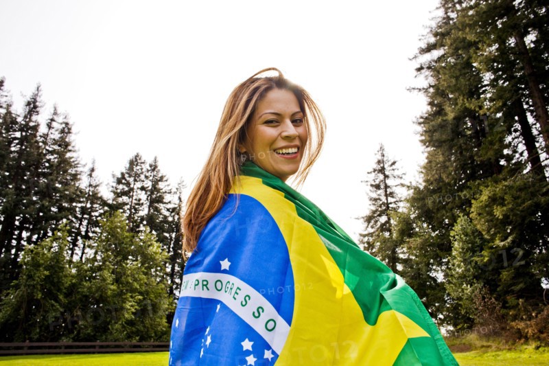 Hispanic woman wrapped in Brazilian flag