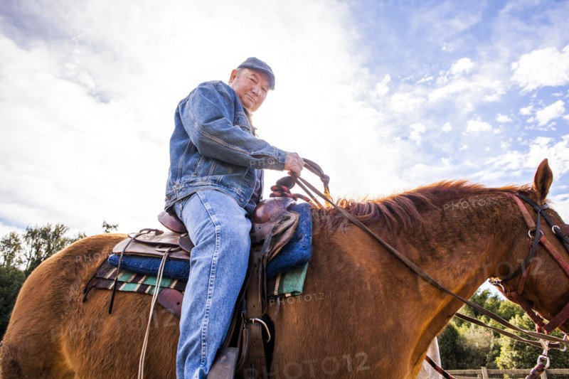 Caucasian rancher riding horse outdoors