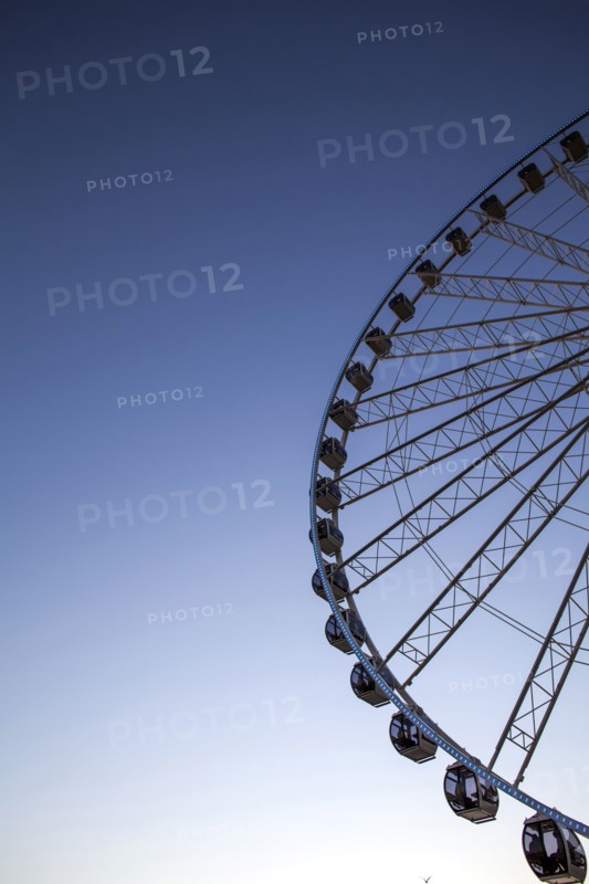 Low angle view of ferris wheel against blue sky