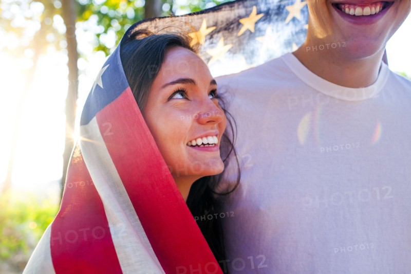 Caucasian couple wrapped in American flag