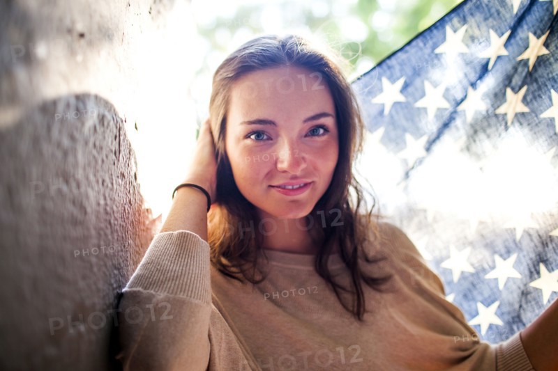 Caucasian woman holding American flag outdoors