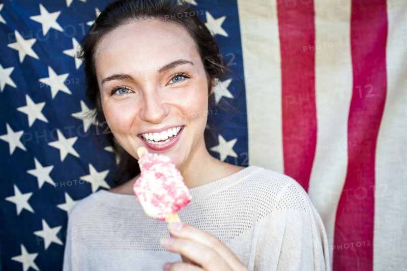 Caucasian woman eating ice cream near American flag