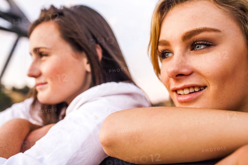 Caucasian teenage girls leaning on banister together