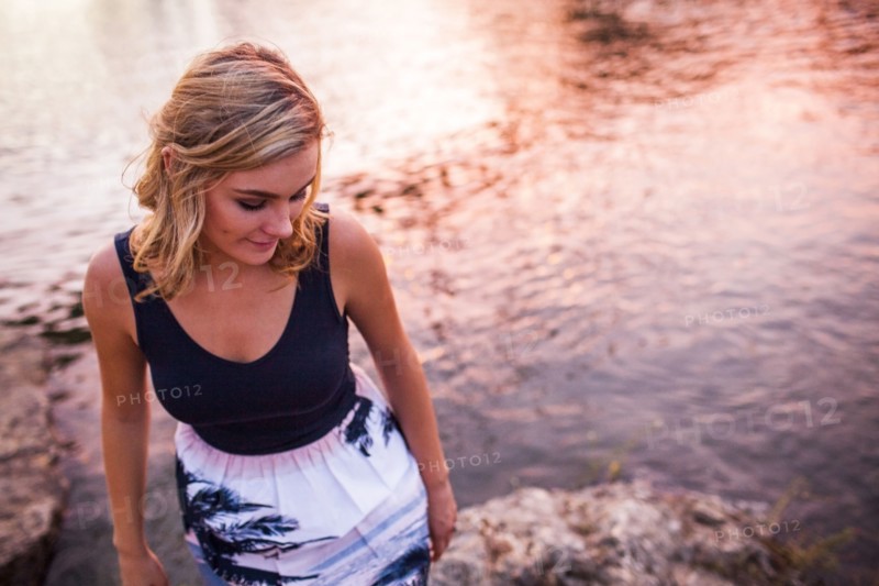 Caucasian teenage girl standing on riverbank