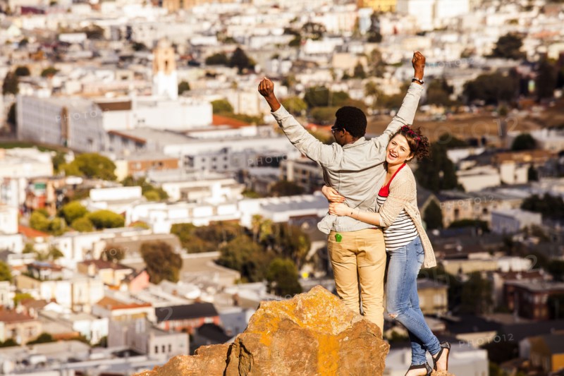 Couple cheering near scenic view of cityscape