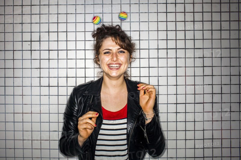 Caucasian woman wearing colorful antenna near wall