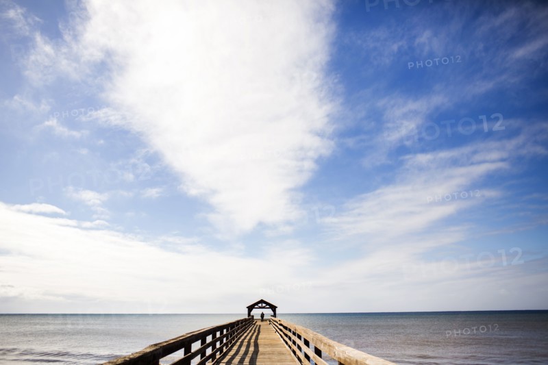 Wooden pier under blue sky over ocean