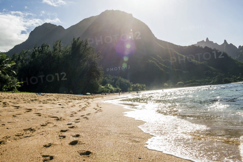 Footprints on sand near waves on tropical beach