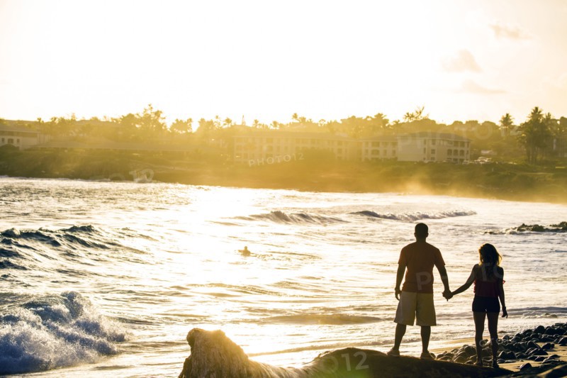 Couple holding hands near ocean on beach