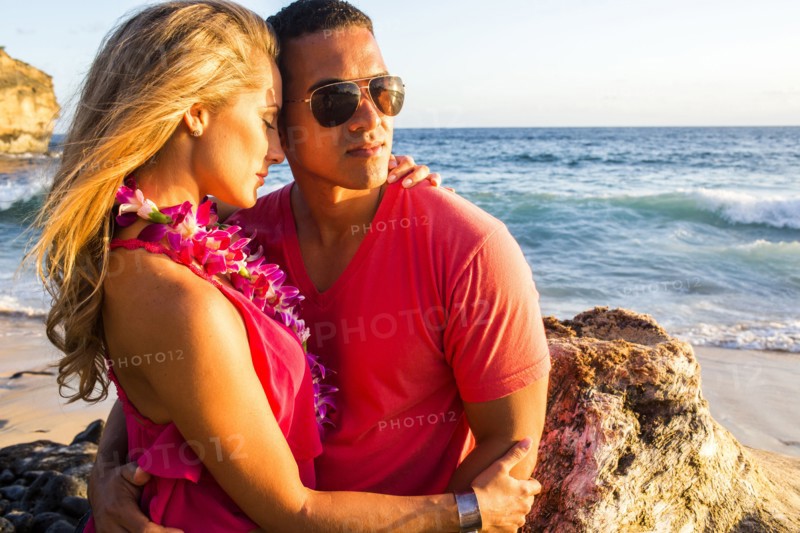 Couple hugging near rock formation on beach