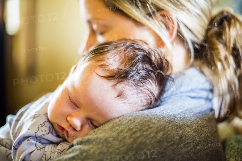 Caucasian mother holding sleeping baby son