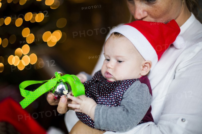 Close up of mother holding baby girl with Christmas ornament