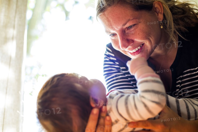 Smiling Caucasian mother cradling baby girl