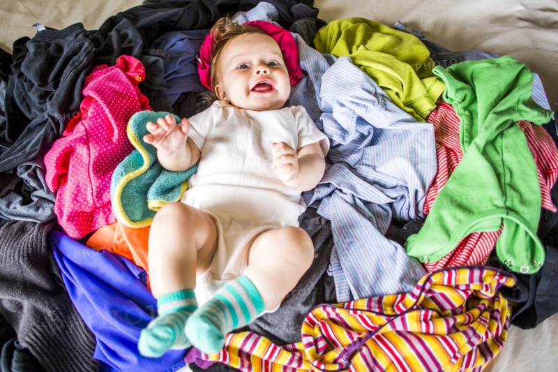 Caucasian baby girl laying in pile of laundry