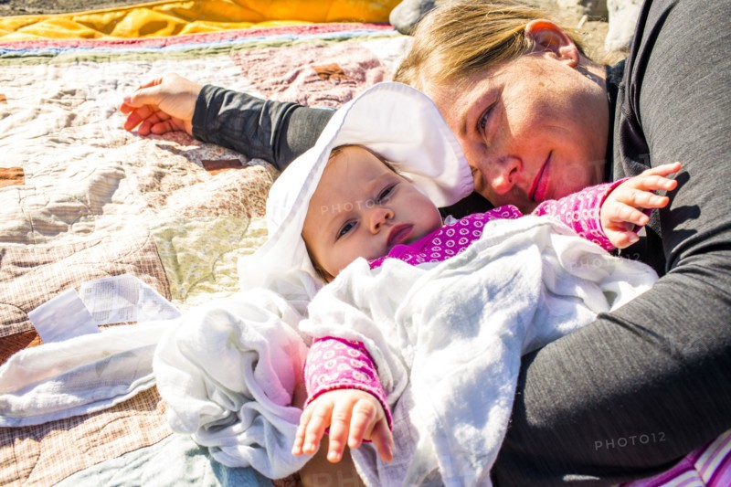 Close up of Caucasian mother and baby girl laying on blanket