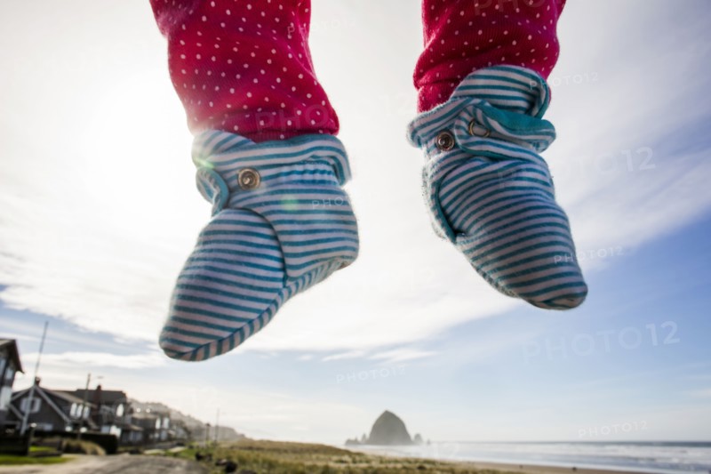 Close up of feet of Caucasian baby hovering over beach