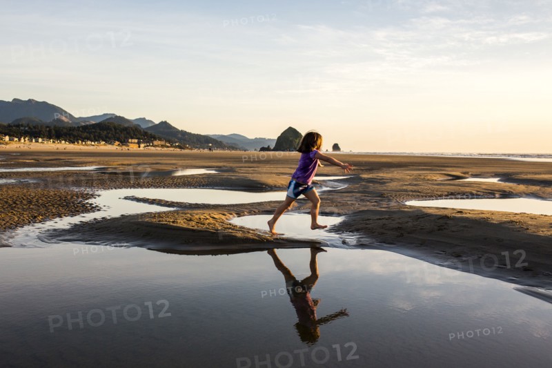 Caucasian girl running in tide pools on beach