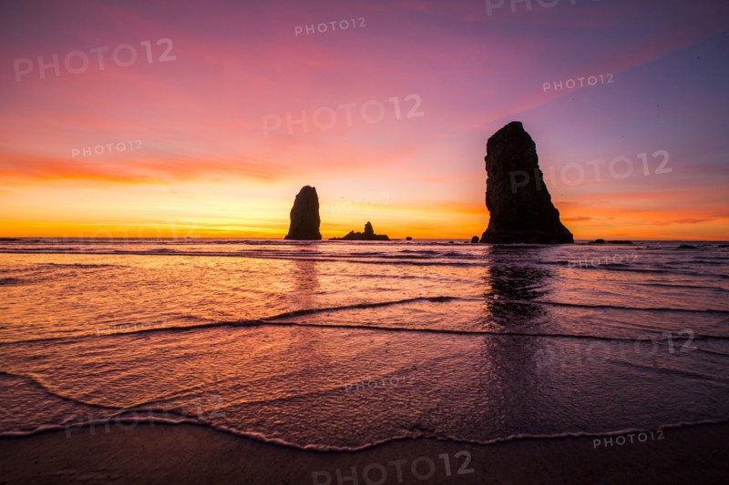 Silhouette of rock formations on Cannon Beach at sunset
