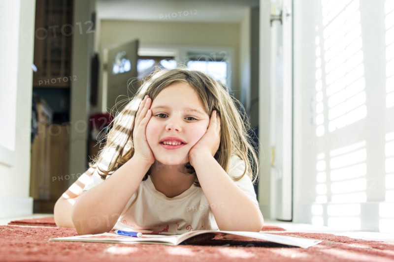 Close up of Caucasian girl reading book on floor