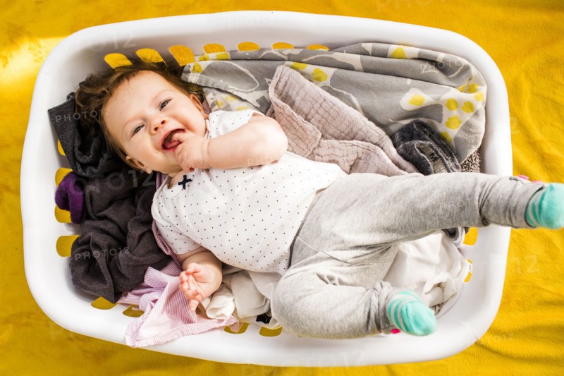 Caucasian baby girl laying in laundry basket