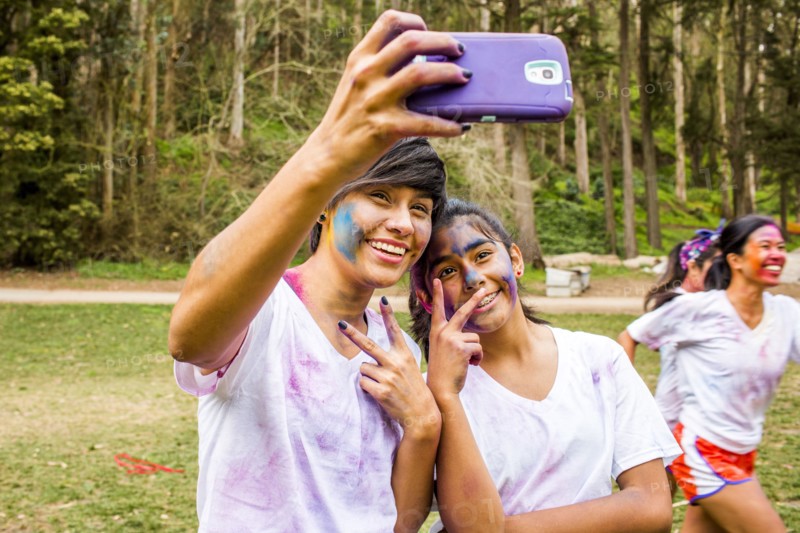 Friends taking selfie covered in pigment powder