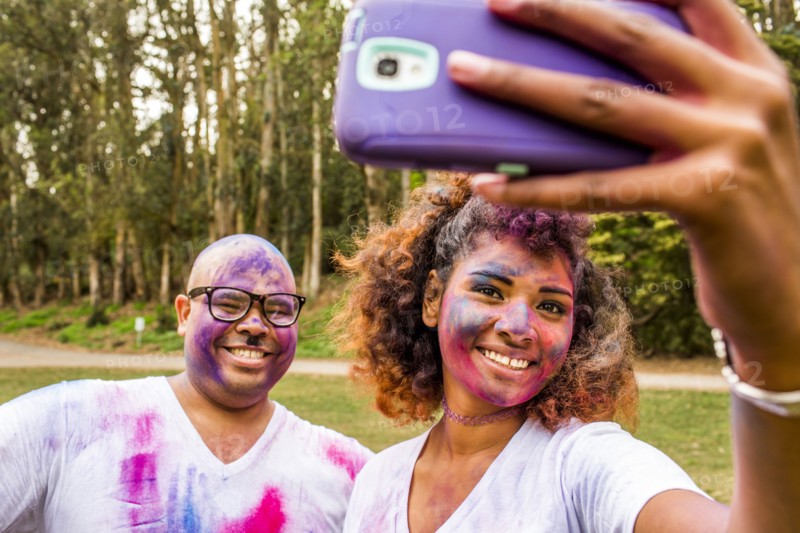Couple taking selfie covered in pigment powder