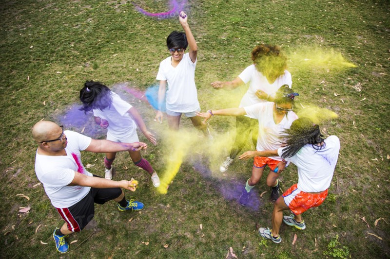 Friends throwing pigment powder in playful fight