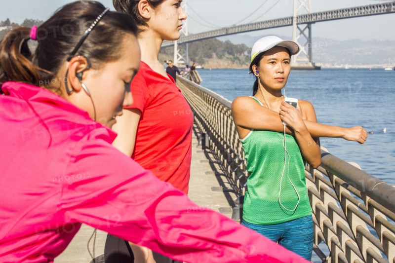 Runners stretching on urban bridge