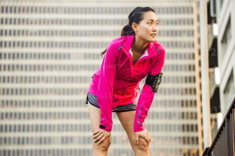 Runner resting near highrise building