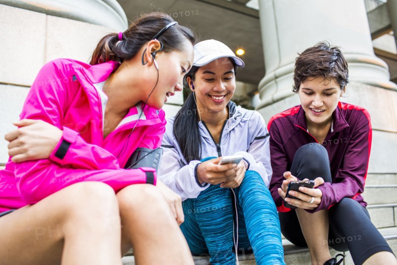 Low angle view of runners using cell phones on staircase