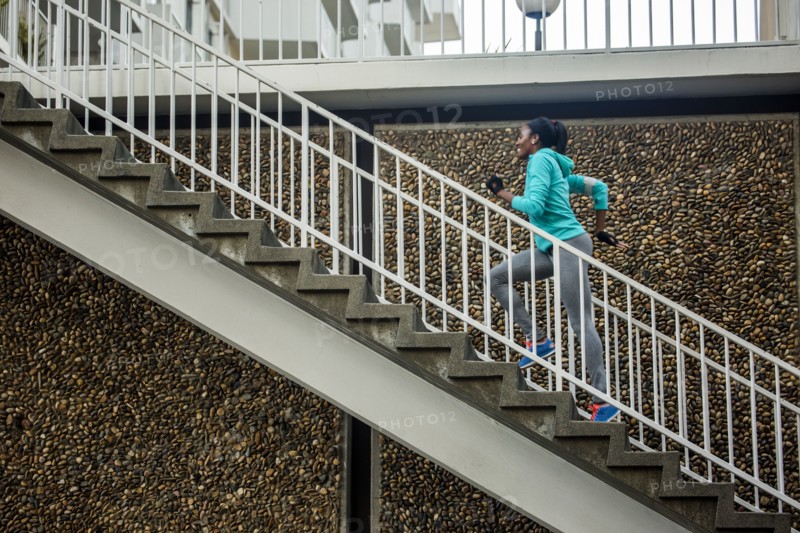 Black runner climbing staircase