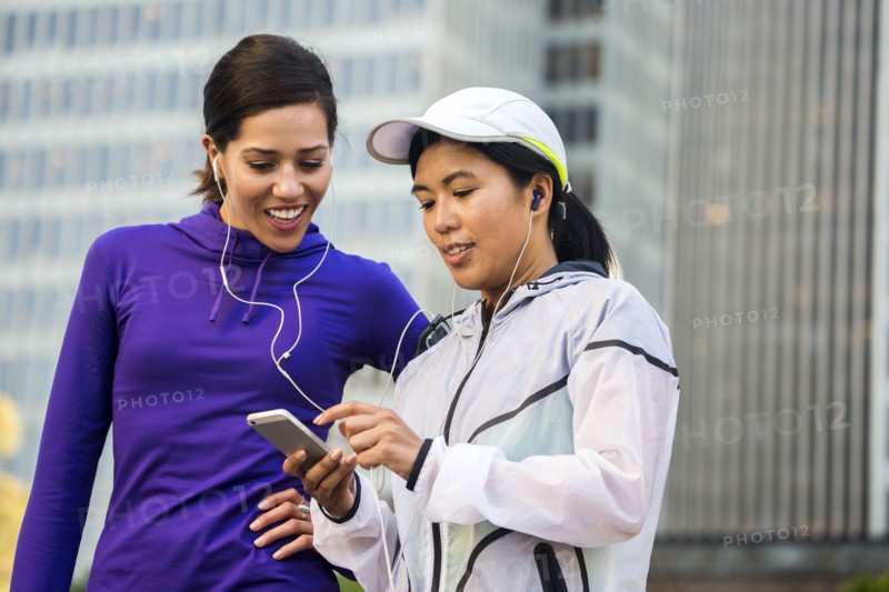 Runners using cell phone near high rise buildings