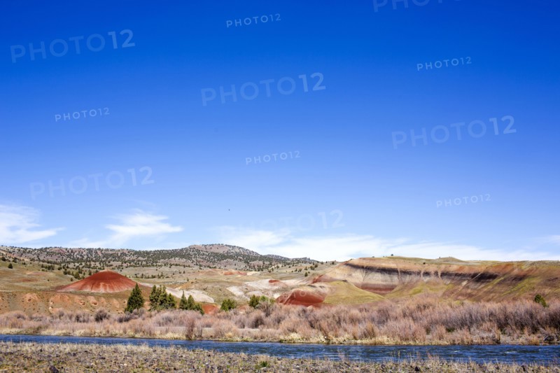 Creek near hills in desert landscape under blue sky