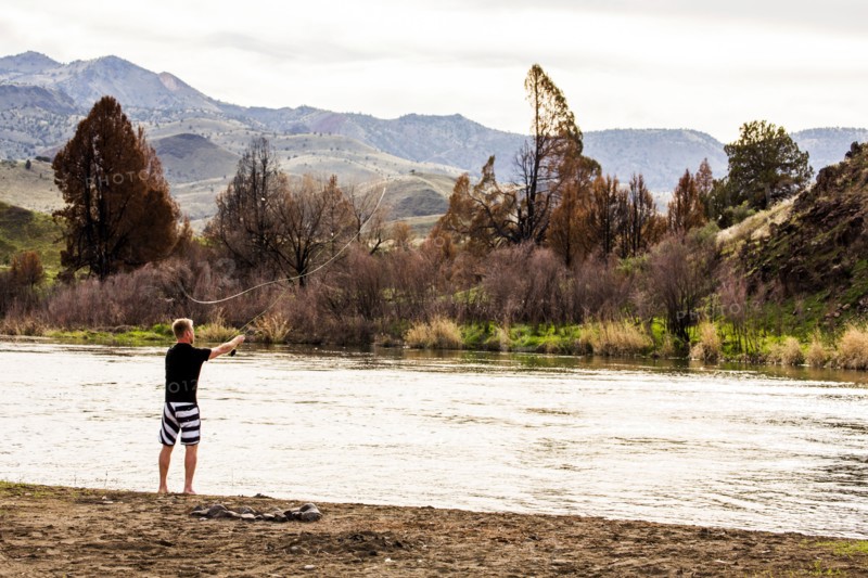 Caucasian man fishing in remote river