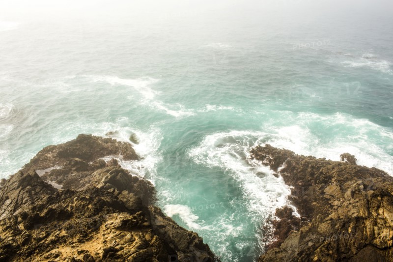 High angle view of ocean waves crashing on cliffs