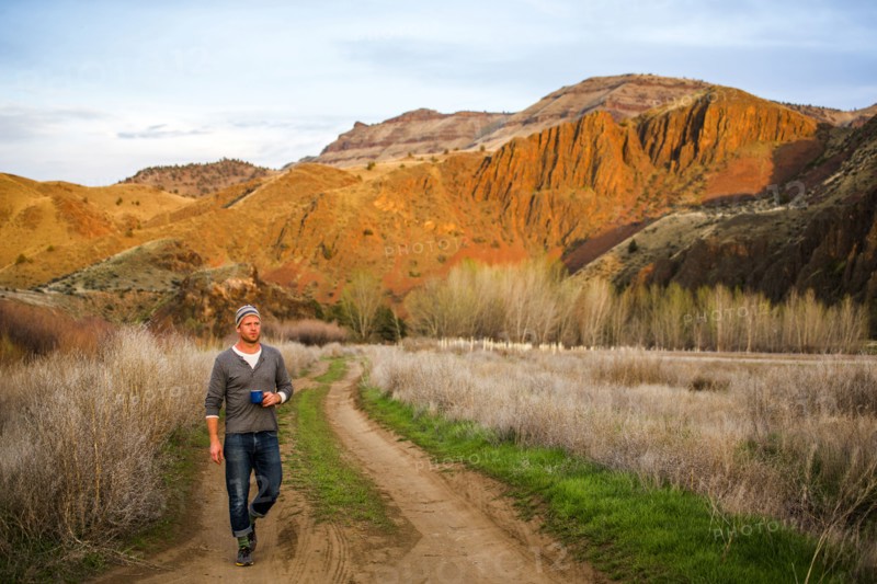 Caucasian man drinking coffee on dirt path